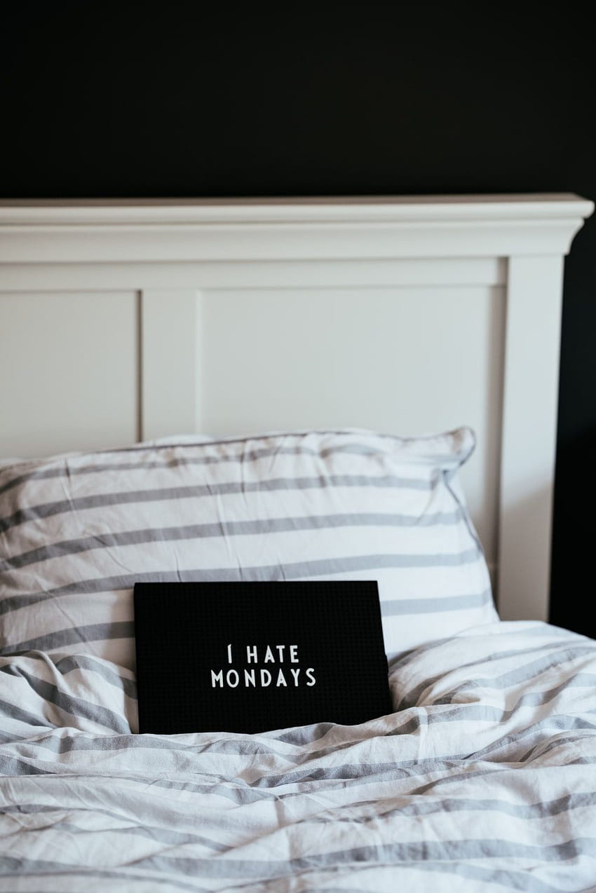 Rechteckige schwarze I Hate Mondays-Leiterplatte auf dem Bett – auf Unsplash HD-Handy-Hintergrundbild