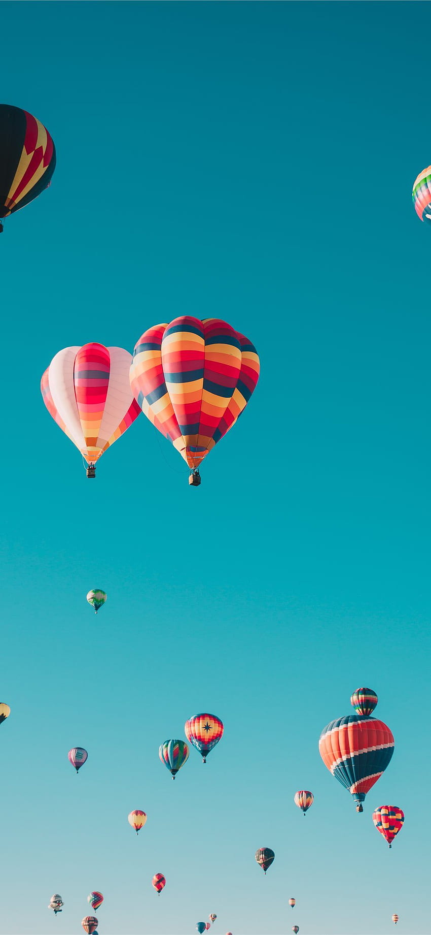 Verschiedene Heißluftballons, die in großer Höhe fliegen. iPhone 11 HD-Handy-Hintergrundbild