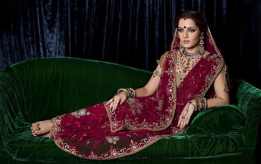 인도 전통 의상을 입은 셀리나 제이틀리, 전통 인단 드레스, 소파에 포즈, 이마에 빈디, 갈색 머리, 빨간색, 보석 HD 월페이퍼