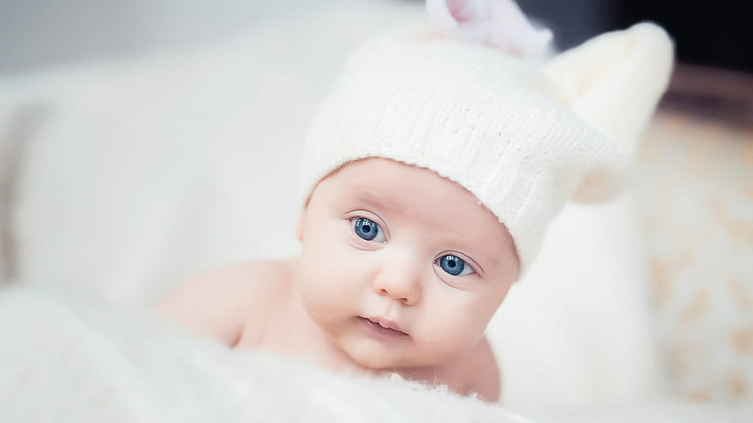 Mavi Gözlü Şirin Yürümeye Başlayan Bebek Kürk Kumaş Üzerinde Beyaz Yün Örme Şapka Giyerek Yatıyor Şirin HD duvar kağıdı