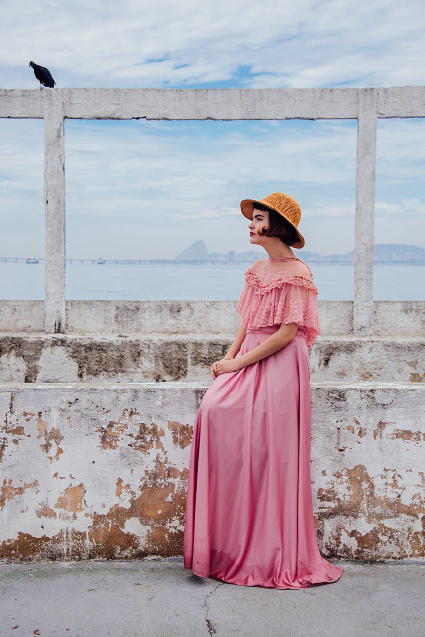 donna che indossa un abito rosa in piedi accanto al muro bianco - Moda Sfondo del telefono HD