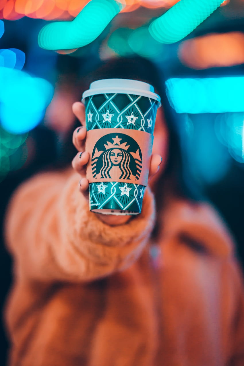жена на кафяво яке, показваща зелена и кафява чаша за кафе Starbucks – кафе Starbucks HD тапет за телефон