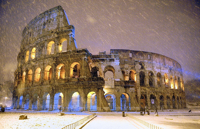 The ancient Colosseum is seen during an heavy snowfalls late in the night in Rome HD wallpaper
